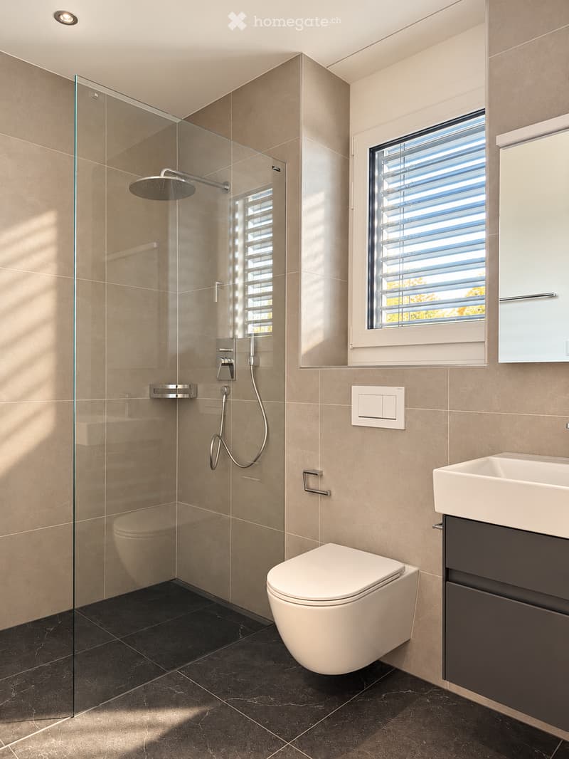 Modern bathroom with beige tiles, black marble flooring, a glass-enclosed shower, a toilet, a sink with a dark cabinet, and a window with blinds.