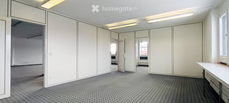Empty room with white walls, grey carpet, and large white sliding partitions. No furniture or equipment visible.