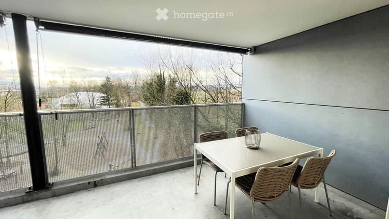 Balcony with a view, white table, and wicker chairs.
