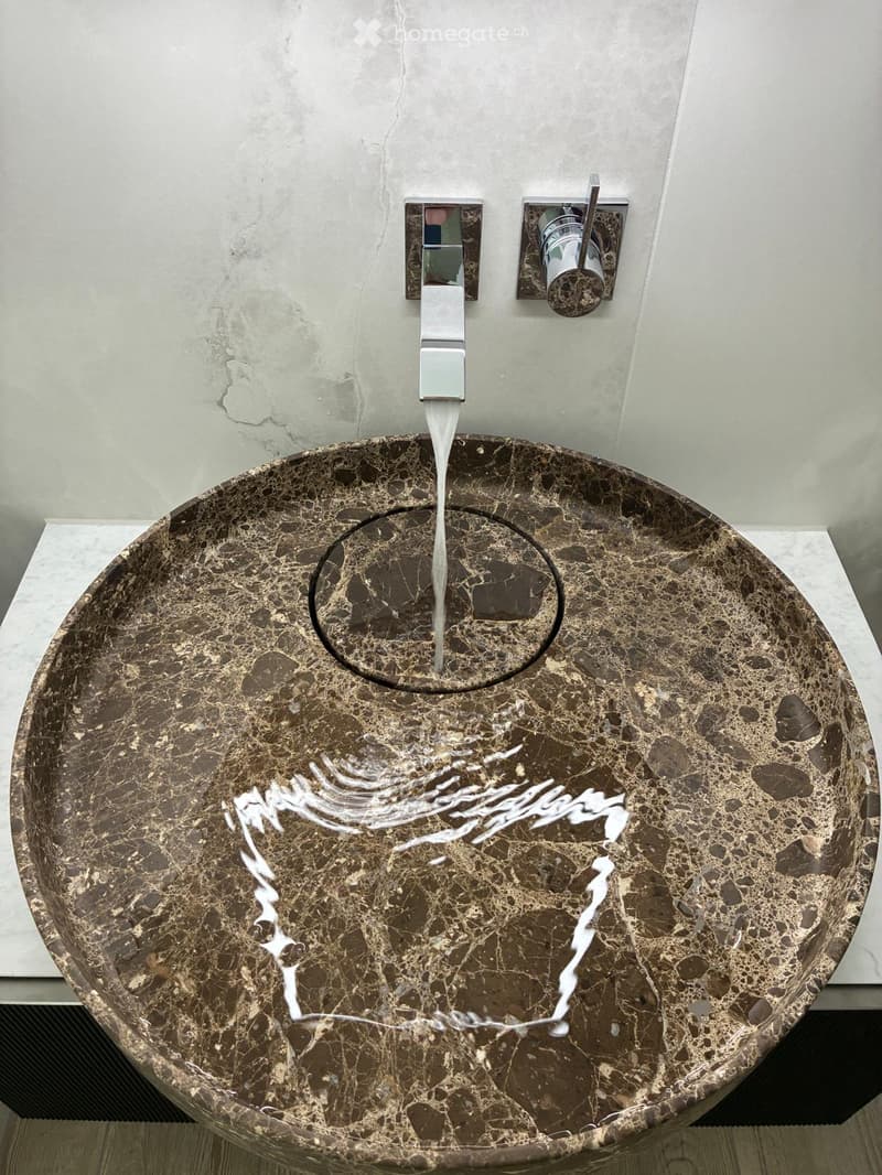 Modern bathroom sink with a sleek, marble-like finish and a contemporary faucet design.