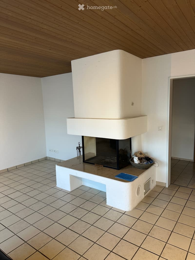 Modern fireplace with white surround, tiled floor, and decorative items on mantel.