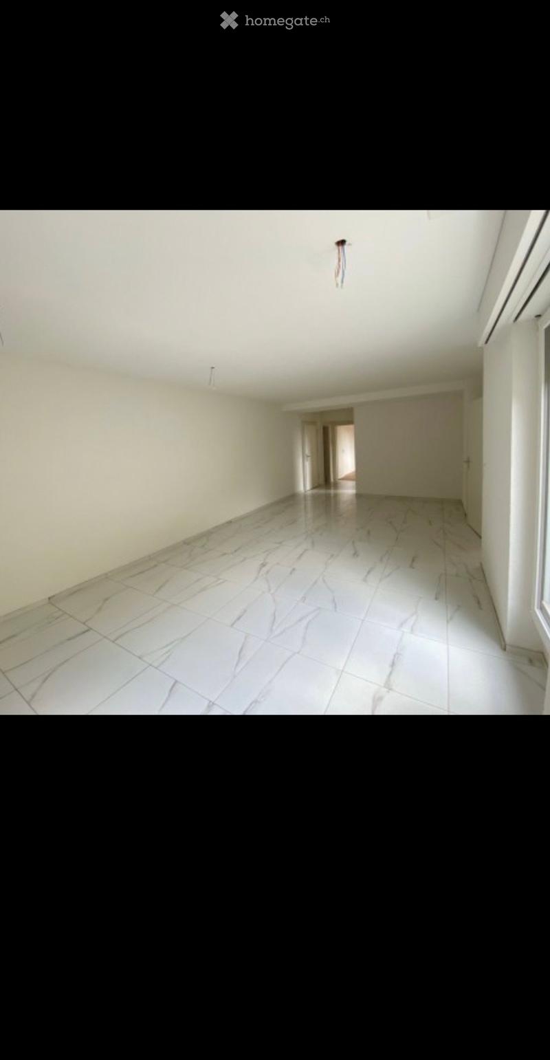 Empty hallway with white walls, marble flooring, and a ceiling light fixture. No furniture or equipment is present.