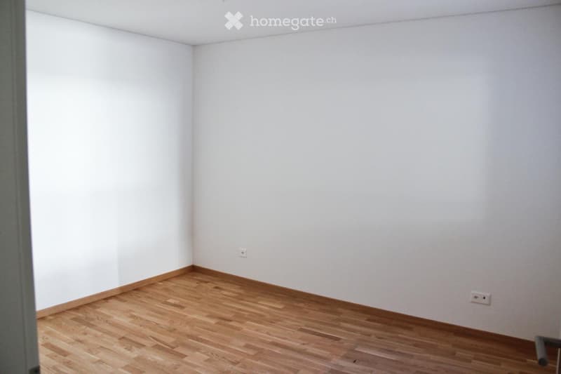 Empty room with white walls and wooden flooring, no furniture or equipment visible.