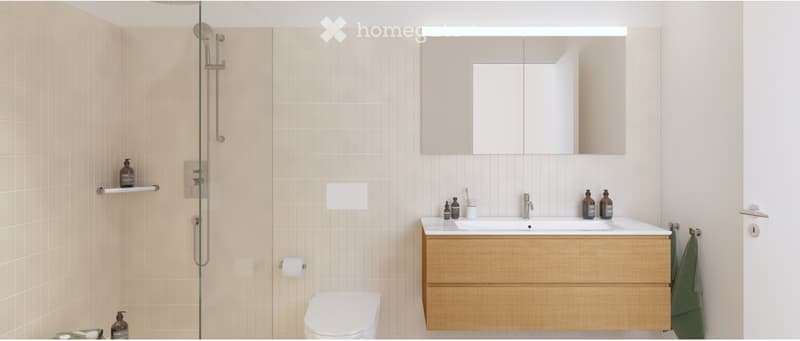 Modern bathroom with beige tiles, a wooden vanity, a large mirror, a shower, and a toilet.