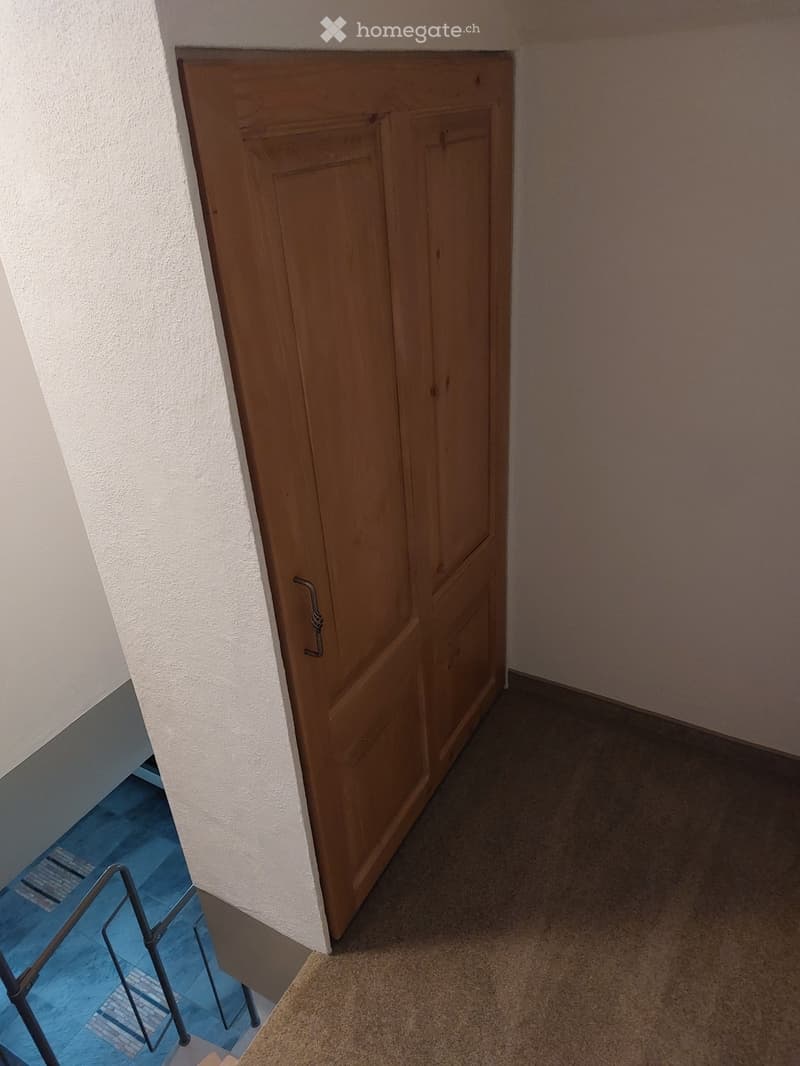 empty room, wooden door, white walls, brown floor