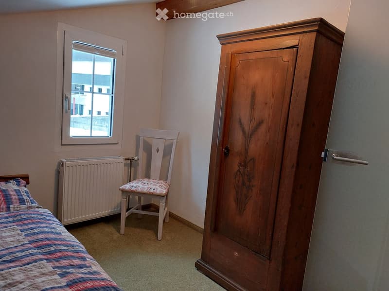 bedroom with a bed, chair, cabinet, and heater