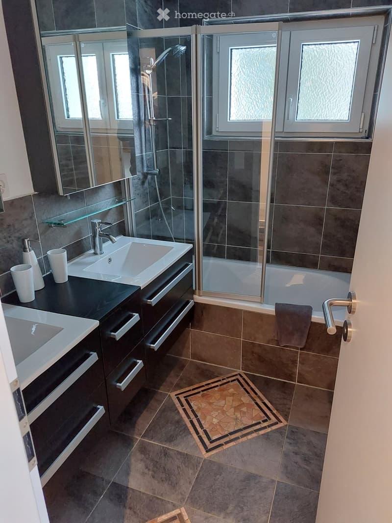 Bathroom with two sinks, mirror, shower area, and bathtub