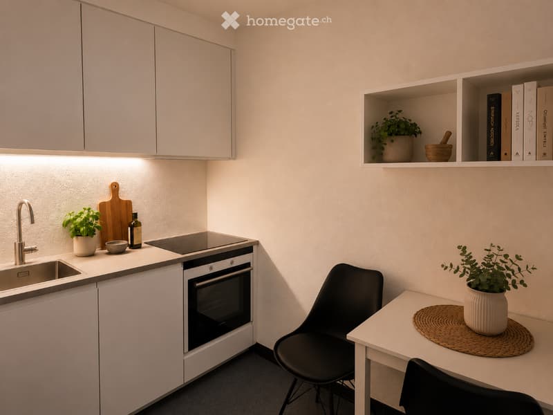 Modern kitchen with white cabinets, a sink, oven, and a small dining area with a chair and table. Shelves hold books and a potted plant.