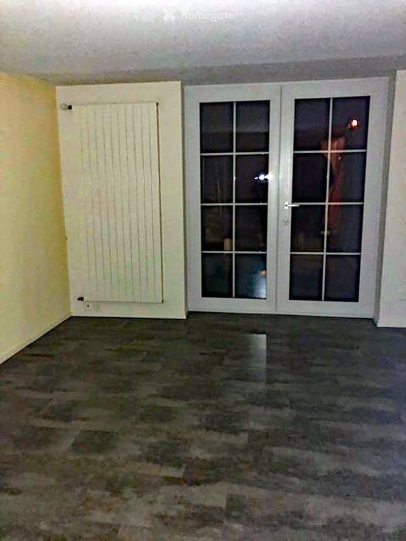 empty room with sliding glass doors, radiator, laminate flooring