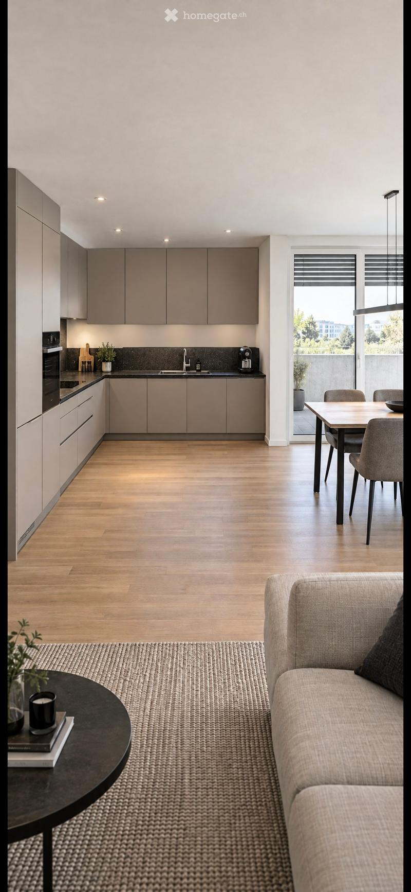 Modern open-plan living and dining area with a sofa, coffee table, dining table, and chairs. The kitchen features sleek cabinets, a sink, and appliances.