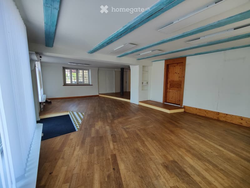 Empty room with wooden flooring, white walls, and a large window. No furniture or equipment is present.