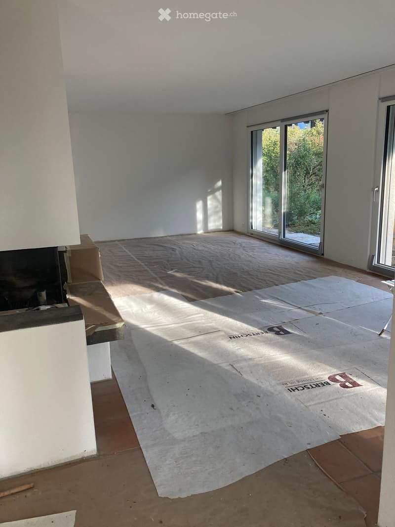 Empty room with white walls, tiled floor, and large sliding glass door leading to outdoor area.