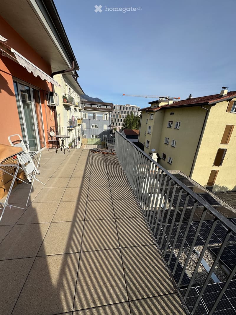Balcony with tiled floor, metal railing, and a small table and chair set.