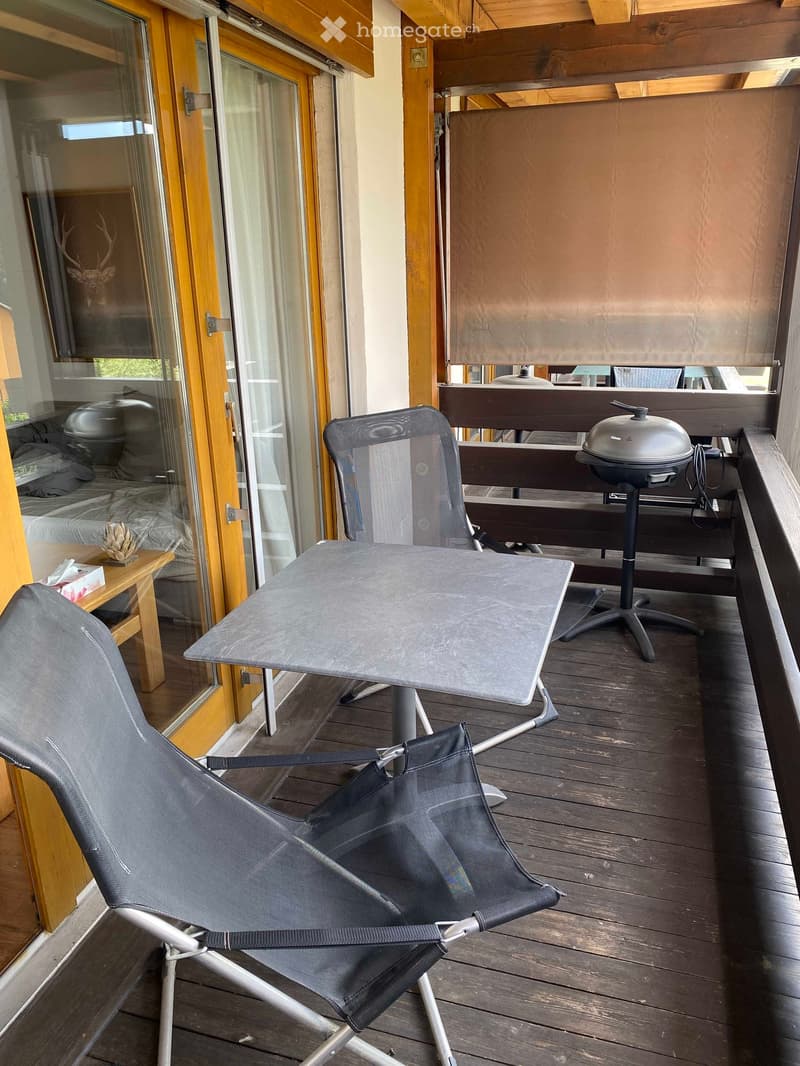 balcony with a table, a griller, and two chairs