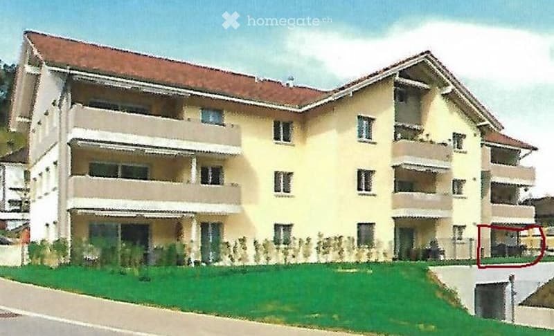 A multi-story residential building with a light yellow facade, multiple balconies, and a well-maintained lawn in front.