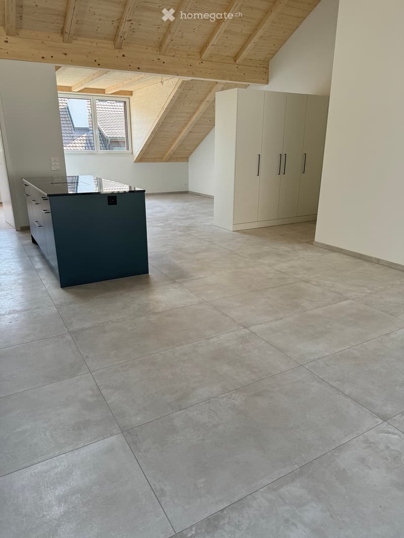 Empty room with tiled floor, white walls, built-in cabinets, and a window with a view of a roof.