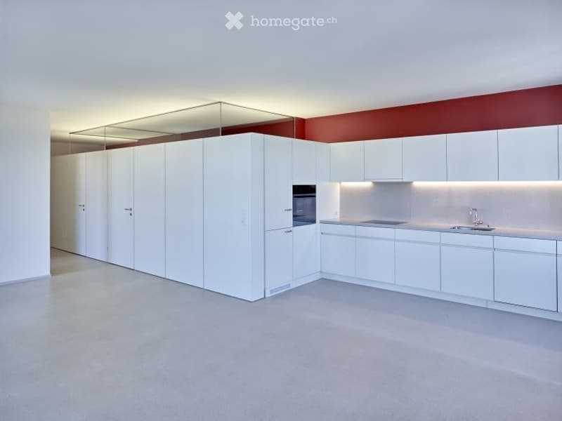 Modern, minimalist kitchen with white cabinets, a built-in oven, and a sleek sink area. The space features a clean, contemporary design with a neutral color palette and ample lighting.