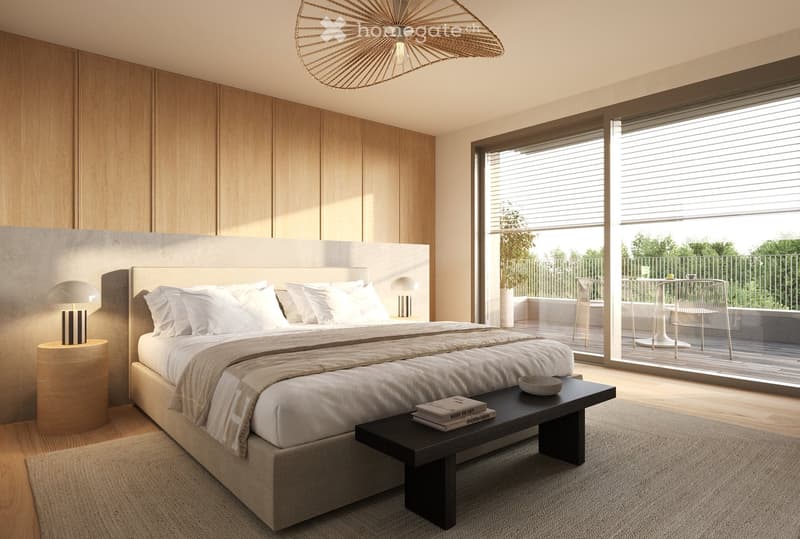 Modern bedroom with a large bed, nightstands, a bench at the foot of the bed, and a balcony with outdoor furniture visible through large windows.