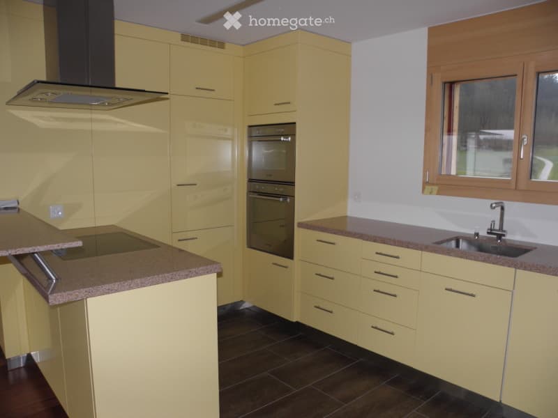 Bright yellow kitchen with modern cabinets, stainless steel appliances, and granite countertops.