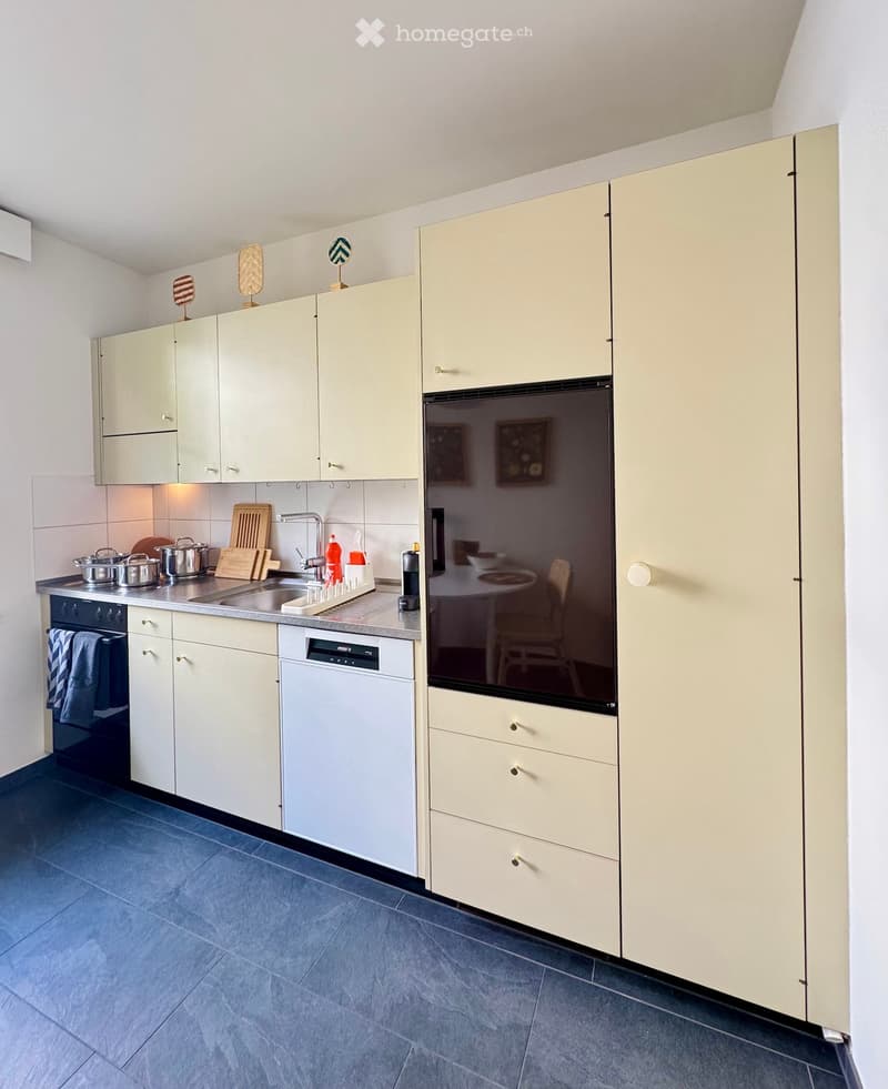 Modern kitchen with light-colored cabinets, stainless steel appliances, and a clean, organized workspace.