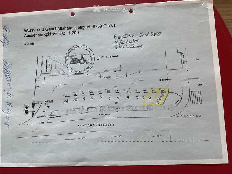 Floor plan of Wohn- und Geschäftshaus Iseliqet, 8750 Glarus, showing parking spaces, entrances, and building layout.