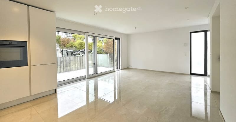 Empty room with tiled flooring, large sliding glass doors leading to an outdoor area, and built-in cabinetry on one side.