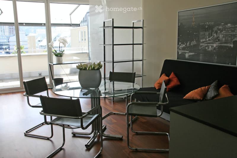 Modern living room with a black sofa, glass table, four chairs, and a shelf with vases. Large windows offer a city view.
