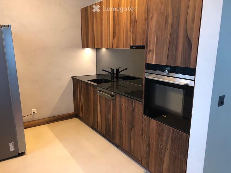 Modern kitchen with wooden cabinets, stainless steel appliances, and a sleek countertop.