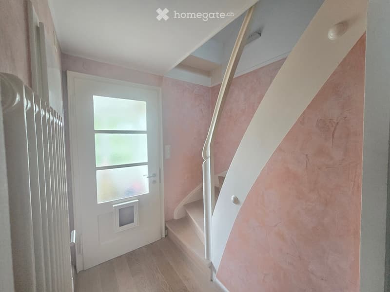 Hallway with a staircase leading upwards, white door with frosted glass panels, and a pet door at the bottom.