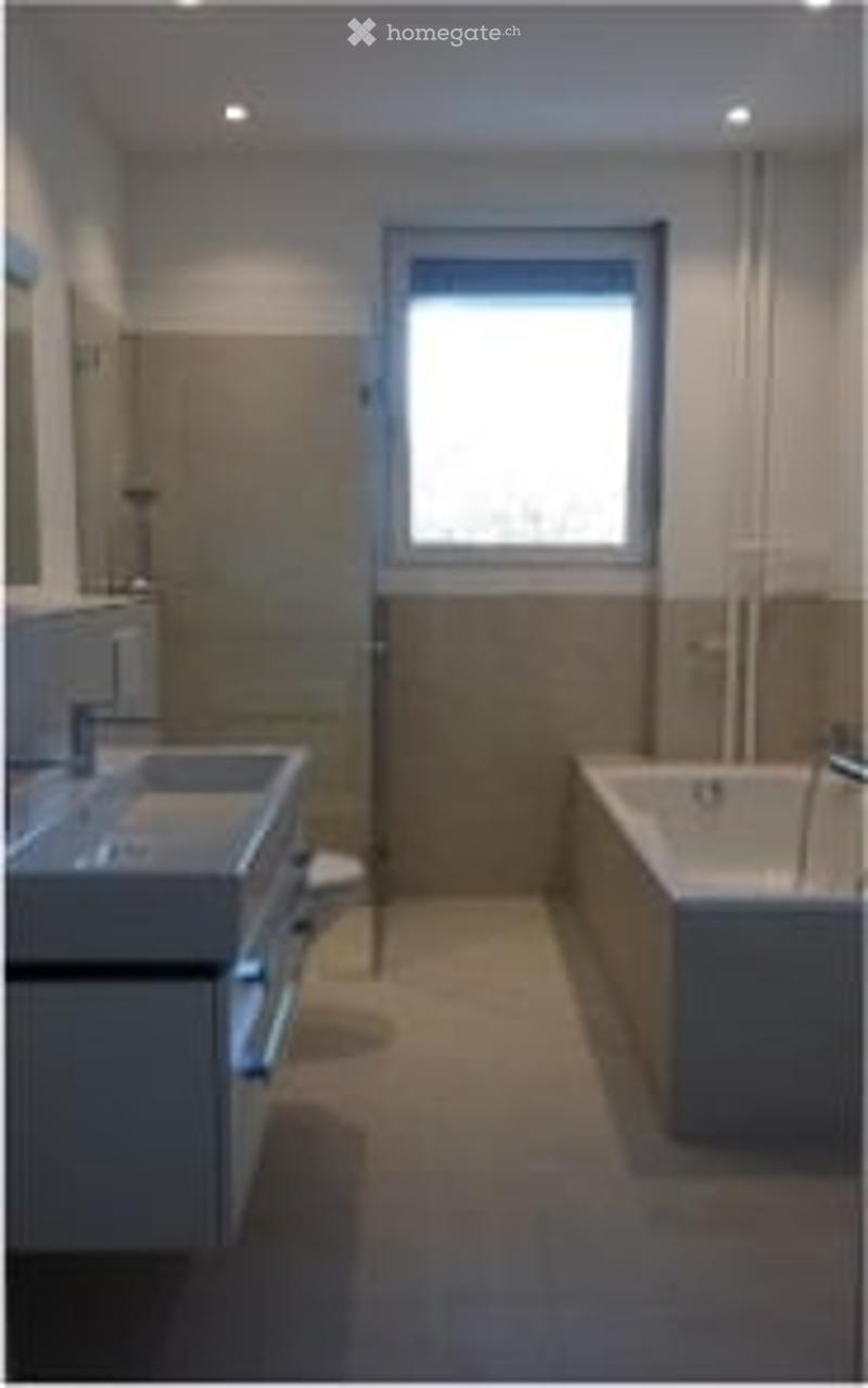 Modern bathroom with a large window, white sink, bathtub, and toilet.