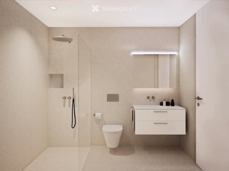 Modern, minimalist bathroom with white tiles, a toilet, a sink with a mirror, and a shower with a handheld sprayer.