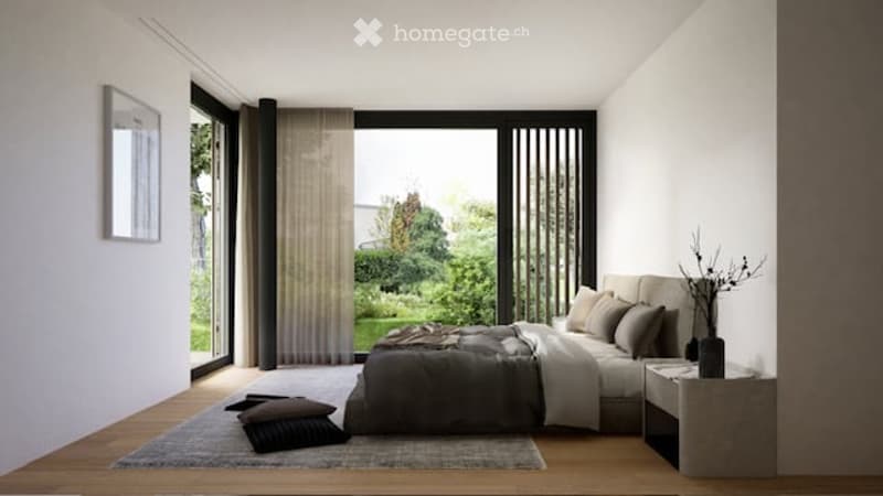 Modern bedroom with large windows offering a view of greenery, a neatly made bed with pillows and a blanket, a nightstand with a mirror, and a vase on the nightstand.