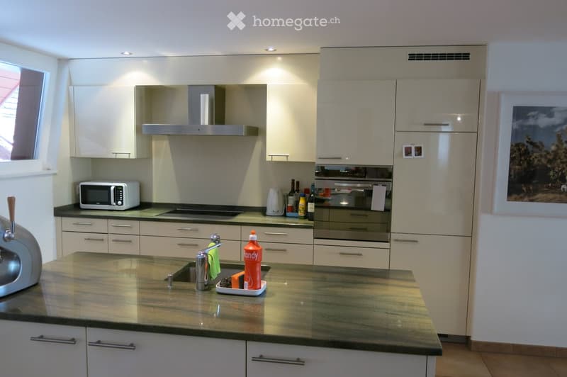 Modern kitchen with white cabinets, stainless steel appliances, granite countertop, and various items including a microwave, oven, and sink.