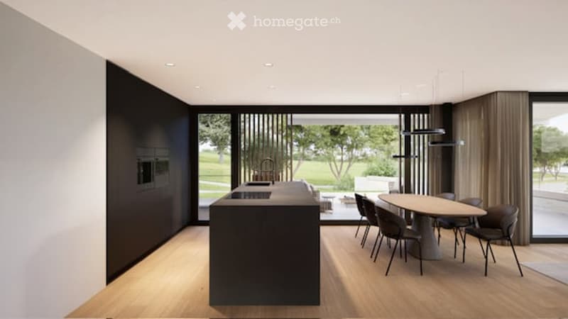 Modern kitchen and dining area with a black kitchen island, a round dining table with chairs, large windows offering a view of a green landscape, and sleek contemporary design.