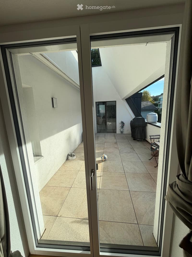 Balcony with tiled floor, visible outdoor furniture, and a ball on the floor.
