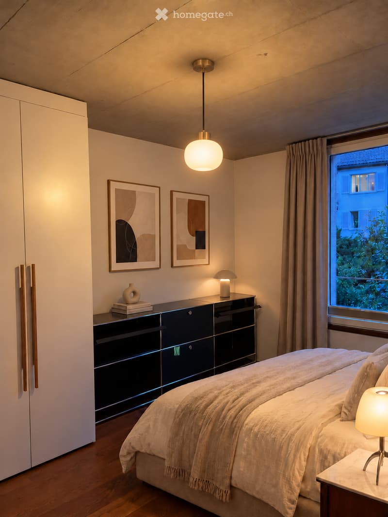 Modern bedroom with a large bed, nightstand, lamp, sleek black cabinet, decorative picture frames, and a vase on the cabinet.