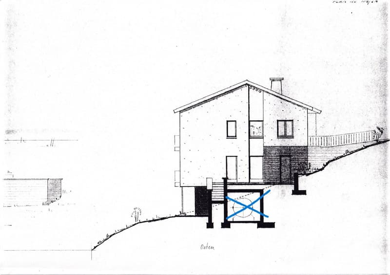 Architectural floor plan of a two-story house with a raised ground floor, featuring a garage, multiple windows, and a sloped roof.