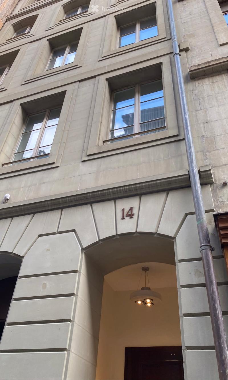 Facade of a multi-story building with large windows and the number 14 displayed above the entrance.