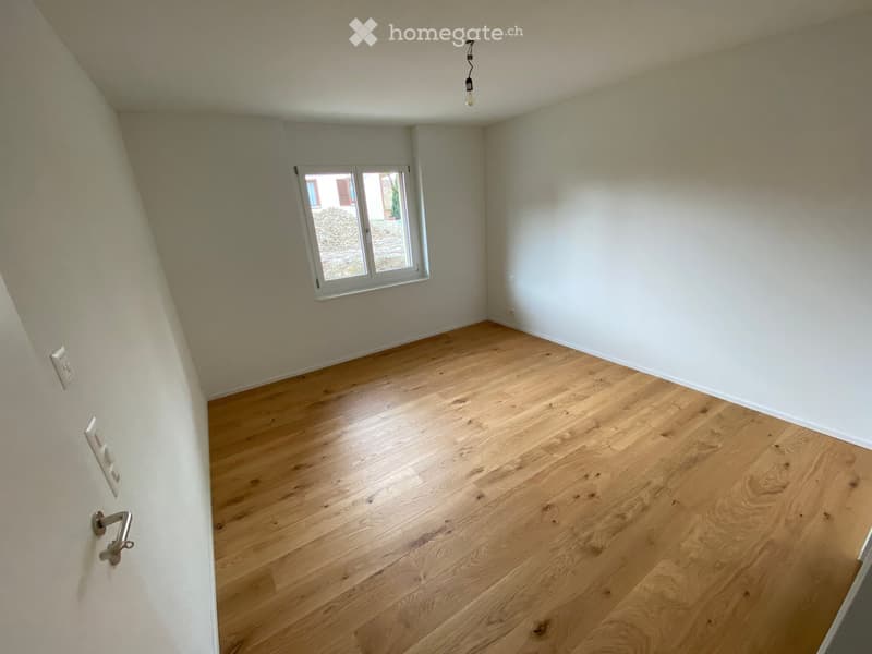Empty room with wooden flooring, white walls, and a single window with white frame. No furniture or equipment present.