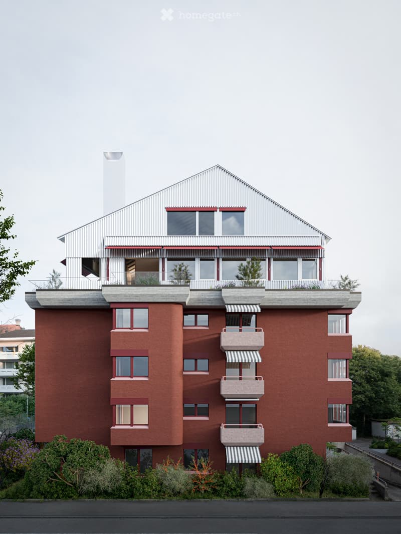 Modern multi-story building with red brick facade, white metal roof, multiple windows, balconies, and small garden area at the base.