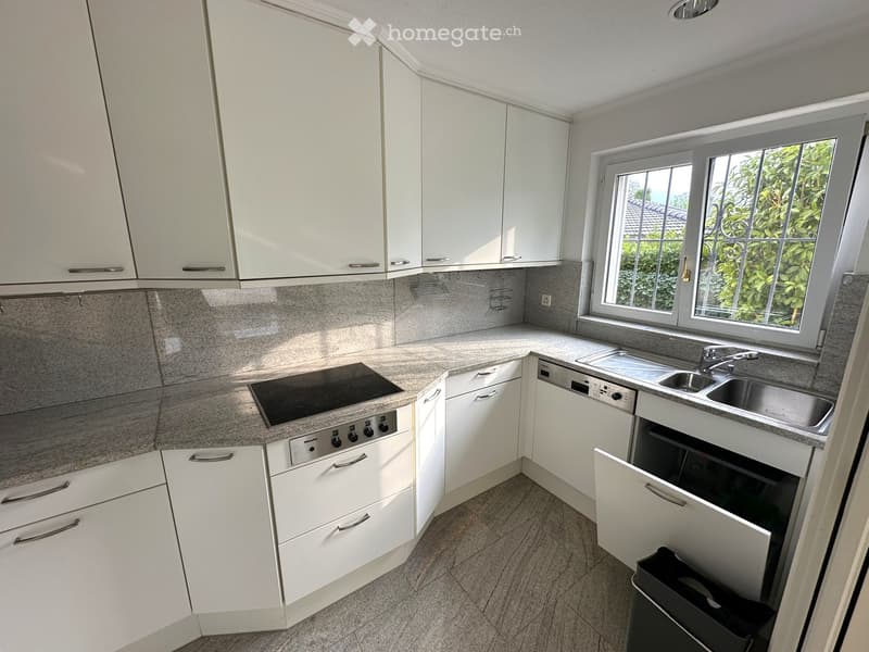 Modern kitchen with white cabinets, granite countertops, stainless steel sink, electric stove, and dishwasher.