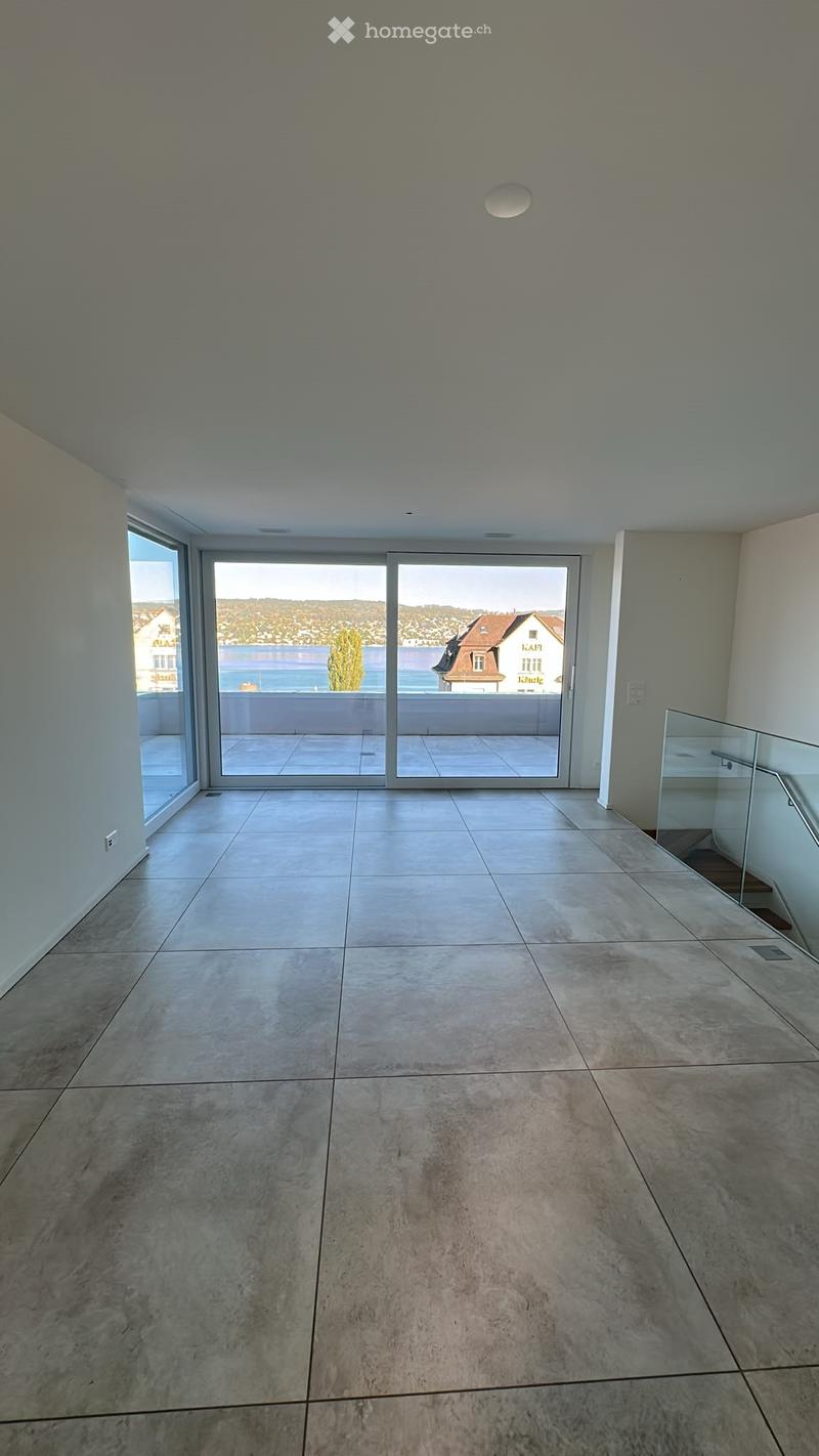 Empty room with large sliding glass doors leading to a balcony, tiled floor, and modern ceiling lighting.