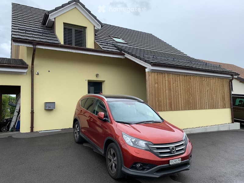 Two-story house with yellow walls, tiled roof, and a garage. A red Honda CR-V is parked in front.