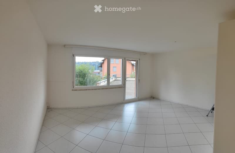 Empty room with white tiled floor and white walls, featuring a large window with a sliding glass door leading to a balcony.
