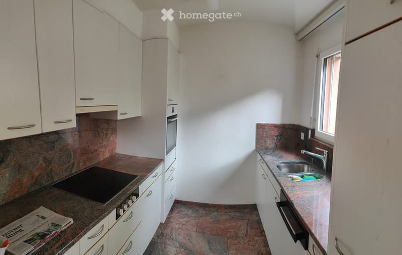 Modern kitchen with white cabinets, granite countertops, electric stove, sink, and a window providing natural light.
