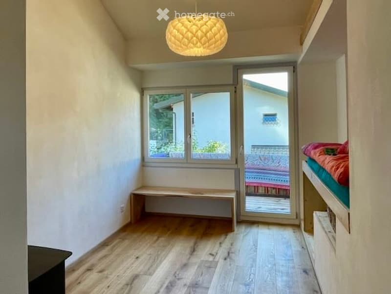 room with wooden floor, white walls, bench, glass doors to balcony