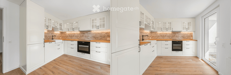 Modern kitchen with white cabinets, wooden countertops, and a brick backsplash. Features include a sink, oven, and ample storage space.