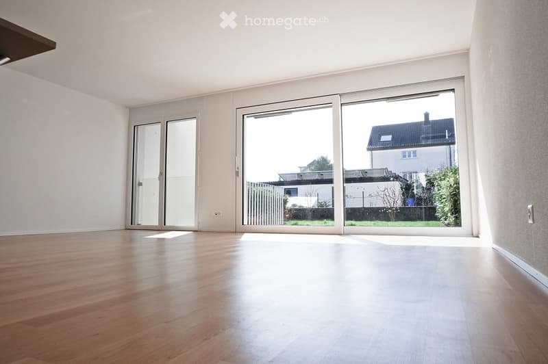 empty living room, hardwood floors, white walls, large sliding glass doors to balcony, white ceiling