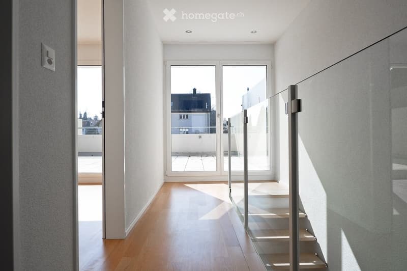 white walls, hardwood floors, glass sliding doors to balcony, stainless steel railing, large windows