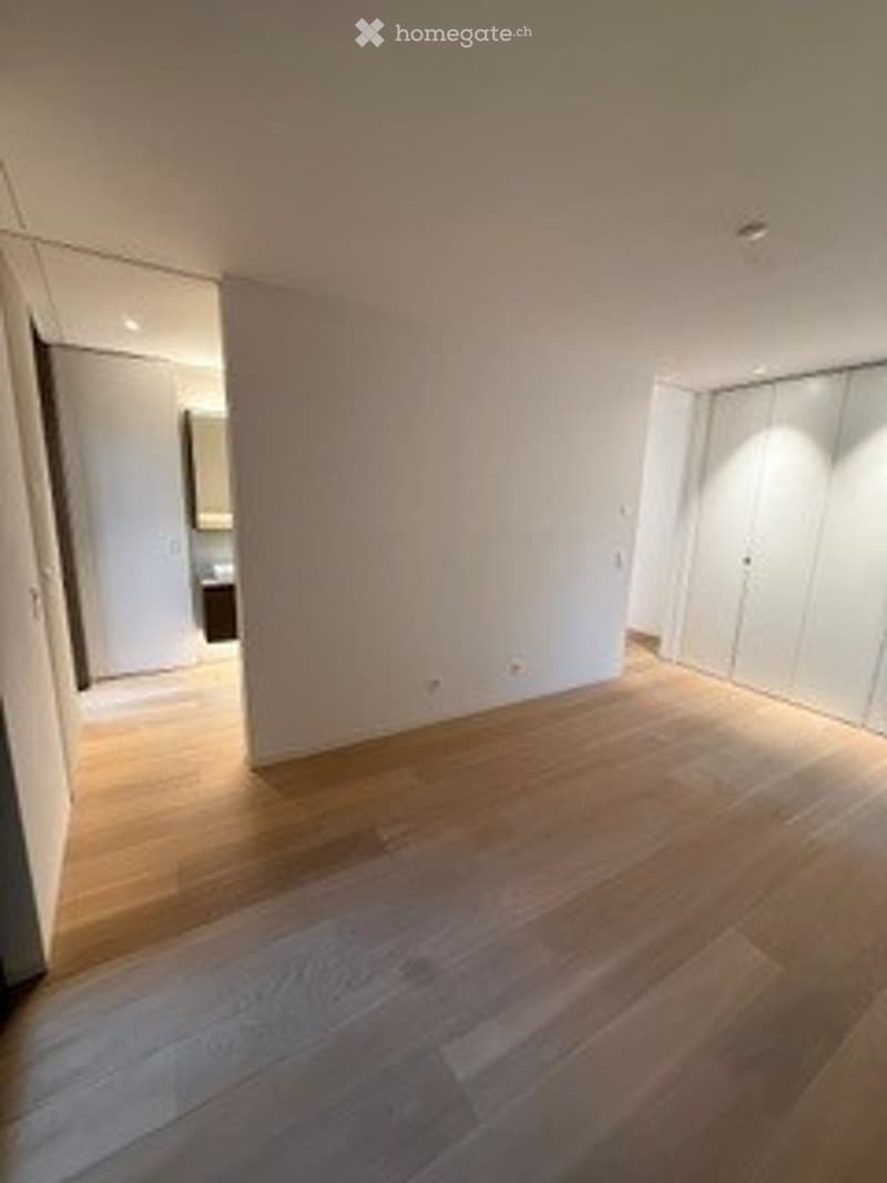 Completely empty room with light wooden flooring and white walls. No furniture or equipment visible.